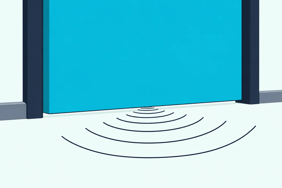 Close-up of the gap under a closed fire door, with sound waves passing through onto the hallway floor