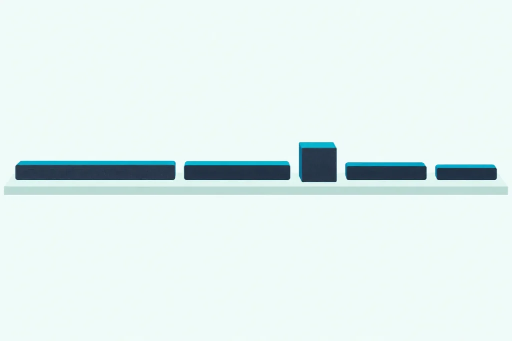 Four slim soundbars of different lengths lined up on a shelf, with a small box subwoofer between two of them