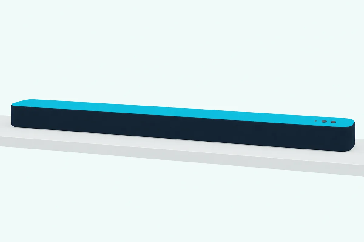 Slim low soundbar on a shelf with three small round dots near one end of its top surface