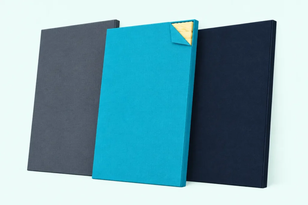 Three fabric-wrapped fiberglass acoustic panels leaning on a wall, one cut open at a corner to show its fiberglass core