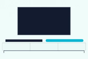 Two long soundbars, one rounded and one flat-topped, on a light console under a large wall-mounted TV with a blank screen